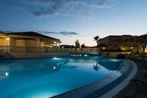 uma piscina à noite com as luzes acesas em Exotica Hotel & Spa by Zante Plaza em Kalamaki