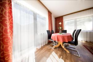 索爾登的住宿－查理民宿，一间用餐室,配有红色的桌子和椅子