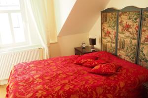 a red bed with red pillows in a bedroom at Luxus Residenz Königstein in Königstein im Taunus