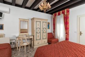 1 dormitorio con cama, escritorio y mesa en Villa Albertina en Venice-Lido