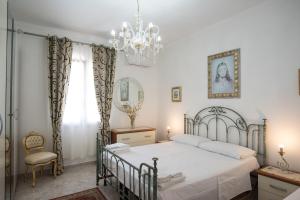 - une chambre avec un lit et un lustre dans l'établissement Alloggio in Villa Cristina B&B, à Gallipoli