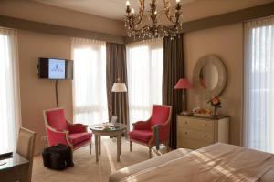 a bedroom with a bed and two chairs and a table at Hof van Putten in Putten