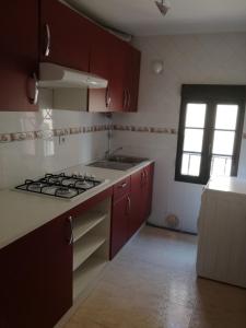 cocina con armarios rojos y fogones en APARTAMENTOS POBRA-CASTELO, en Pobra do Caramiñal