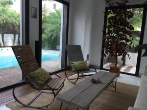 a living room with two chairs and a wooden bench at la casa de las pergolas in Seville