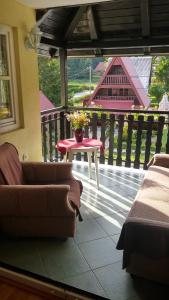 a living room with a table and a couch on a porch at Apartment Petra in Mrkopalj