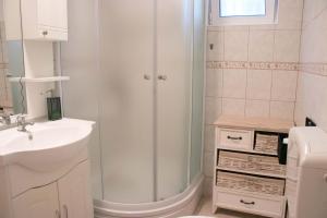 a white bathroom with a shower and a sink at Apartment Lorena in Sevid +22 photos