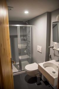 a bathroom with a shower and a toilet and a sink at Hotel Vittoria - Ca' De La Montagna in Montespluga