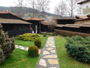 einen Garten mit einem Steinweg im Hof in der Unterkunft Family Vacation Home Topolnitza in Kopriwschtiza