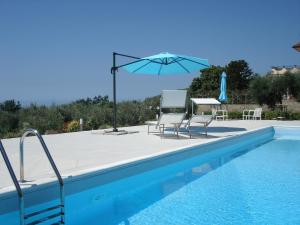 a swimming pool with two chairs and an umbrella at Globetrotter in Formia