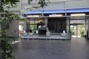 an office lobby with chairs and a reception desk at Les Thermes in Dax +26 photos