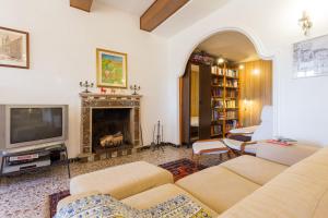 ein Wohnzimmer mit einem TV und einem Kamin in der Unterkunft Appartamento il Grillo in Fossato di Vico