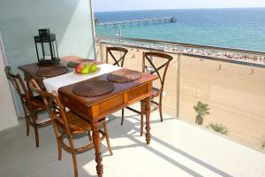 バダロナにあるGreat Sea-Side Barcelona Apartmentのビーチを望むバルコニー(テーブル付)
