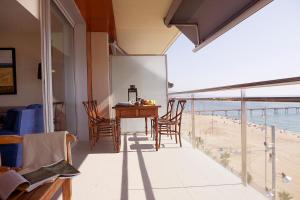 a dining room with a table and chairs and the beach at Great Sea-Side Barcelona Apartment in Badalona