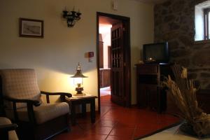 a living room with a chair and a television at Casa Pissarra in Linhares