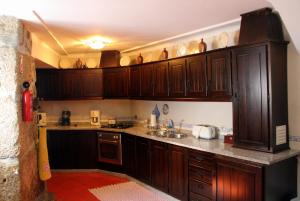 a kitchen with wooden cabinets and a sink at Casa Pissarra in Linhares