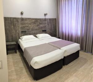 チホレツクにあるArt Hotelのベッドルーム1室(大型ベッド1台、木製ヘッドボード付)