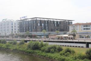 a large building next to a river with a bridge at Les Thermes in Dax