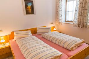 two beds sitting on top of a bed in a room at Appartement Seibl in Sankt Johann in Tirol