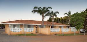 una casa con una palmera delante de ella en Rhodeside Lodge, en Geraldton