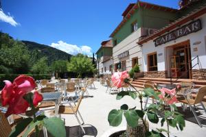 un patio con mesas y sillas frente a un edificio en Hotel Rural Montaña de Cazorla, en Arroyo Frío