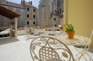 a patio with tables and chairs on a balcony at Aspalathos Residence in Split