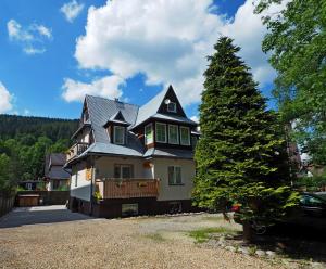 a large house with a tree in front of it at Willa Cicha Woda Centrum in Zakopane