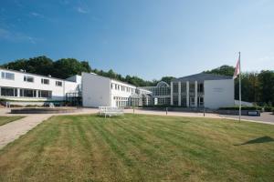 ein Gebäude mit einem Grasfeld davor in der Unterkunft Hotel Juelsminde Strand in Juelsminde