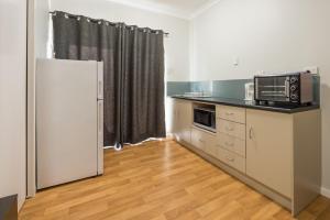 eine Küche mit einer Mikrowelle und einer Arbeitsplatte in der Unterkunft Rhodeside Lodge in Geraldton