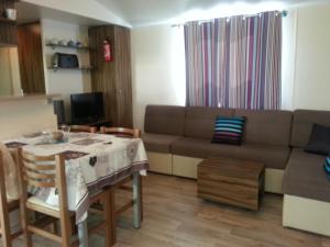 a living room with a couch and a table at Les Charmettes Mobilhomes17 in Les Mathes +17 photos