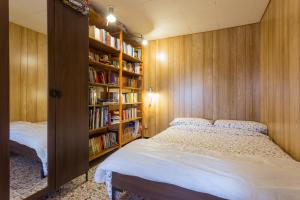 ein Schlafzimmer mit einem Bett und einem Bücherregal in der Unterkunft Appartamento il Grillo in Fossato di Vico