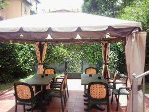 Hotel Nizza في ميلانو: فناء به طاولات وكراسي تحت مظلة