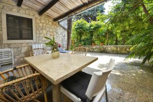 una mesa de madera y sillas en un patio en Villa Funtana, en Funtana