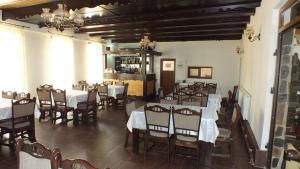 a dining room with tables and chairs and a bar at Pensiune Restaurant la Pogace in Săpânța