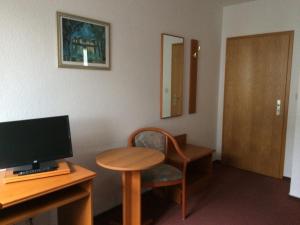 a room with a desk with a computer and a chair at Zur Krone in Seelze