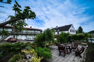 a patio with a table and chairs and a building at Na Poczatku - Apartamenty in Darłowo