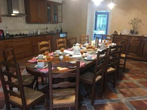 een keuken met een houten tafel met eten erop bij Les chambres de La Métairie du Dick in Pleurtuit