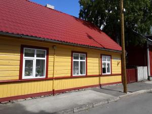 un edificio amarillo y rojo con techo rojo en Theodori Holiday House, en Pärnu