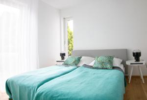 ein Schlafzimmer mit einem Bett mit einer blauen Decke in der Unterkunft Bei Meyers im Leipziger Neuseenland in Großdeuben