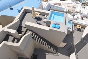 uma vista aérea de um edifício branco com uma piscina em Aria Suites & Villas em Fira