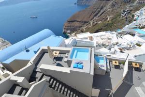 arial view of a white building with a view of the ocean at Aria Suites & Villas in Fira