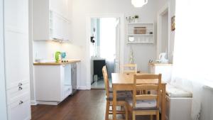 a kitchen and dining room with a table and chairs at Home3city Kameralny in Sopot