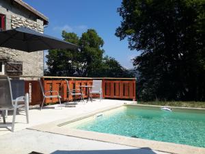 a swimming pool with a table and chairs and an umbrella at Casa Arnera in Andon