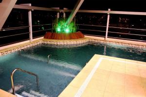 uma piscina com uma fonte num edifício em Ros Tower Hotel em Rosário