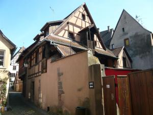 an old building in an alley with a fence at La cour des meuniers - le Froment et l'Epeautre in Kaysersberg