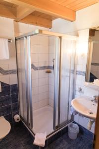a bathroom with a shower and a sink at Schnider Bed&Breakfast und Café in Vals