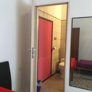 a bathroom with a red door and a toilet at Casa Ale in Marghera