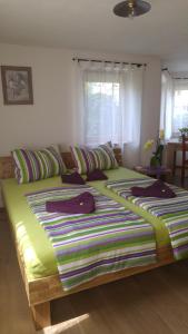 ヘルボルツハイムにあるHaus am Bergliの緑色のベッドカバーが備わる客室の大型ベッド1台分です。
