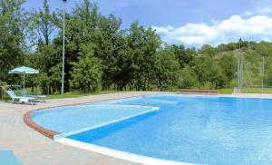 a swimming pool with a chair and an umbrella at House Roberto by Holiday World in Castel del Piano