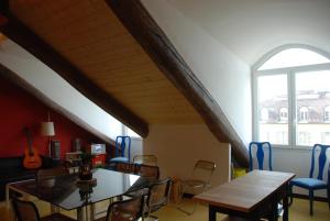 een kamer met een tafel en stoelen en een gitaar bij Attic Hostel Torino in Turijn