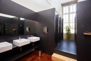 a bathroom with two sinks and a large mirror at The Passenger Hostel in Porto